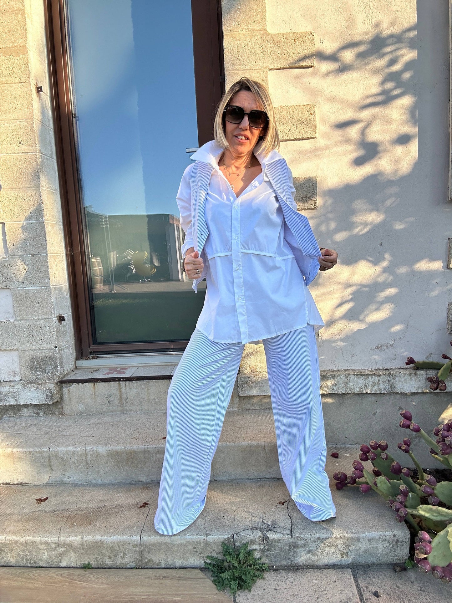 Chemise oversize blanche femme Milan, portée avec un pantalon fluide pour un style chic et confortable, idéal pour la mode 2025.