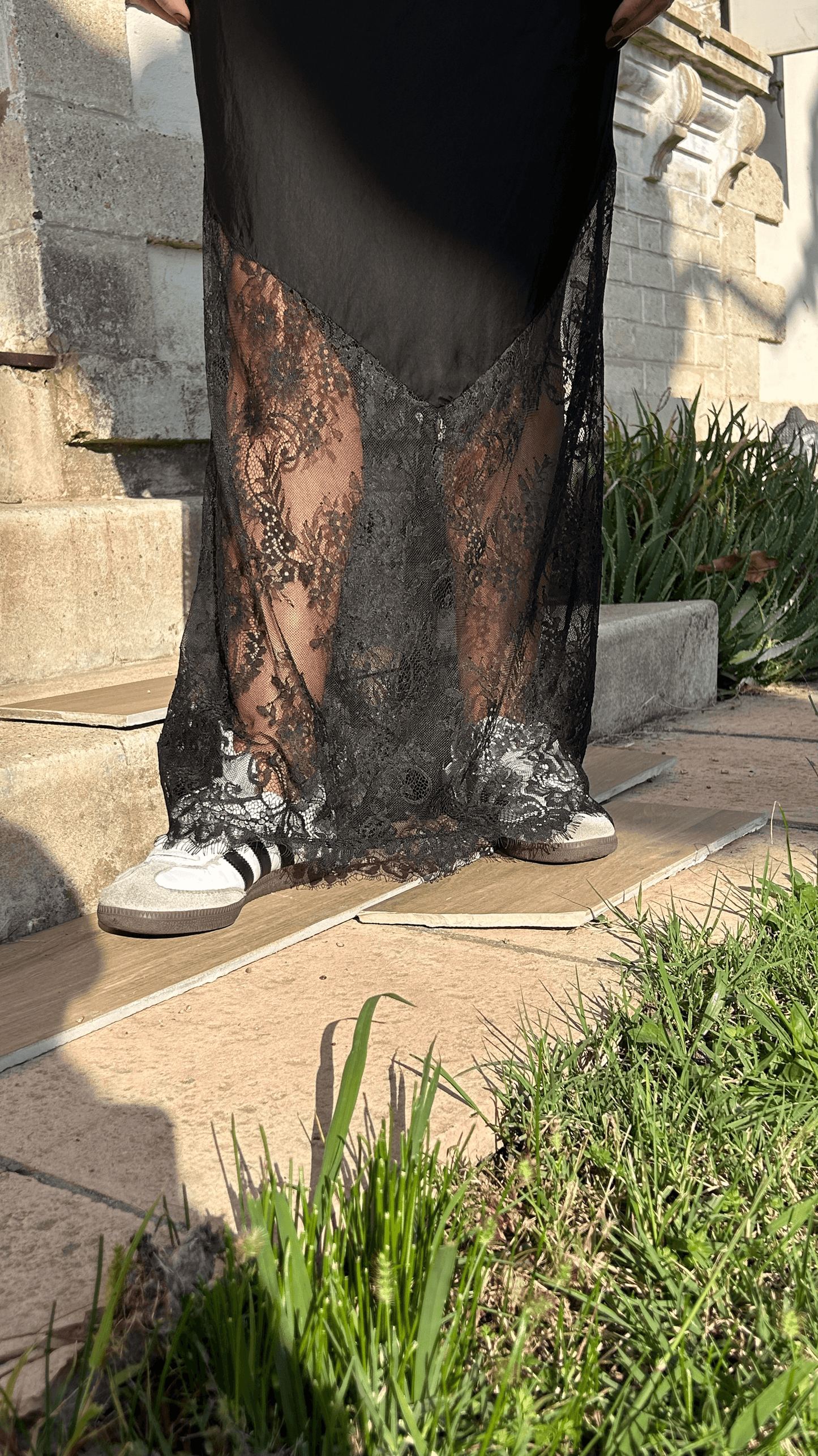 Jupe longue Ava en satin et dentelle noire tenue quotidienne. Coupe fluide finition dentelle raffinée. Idéal pour un look tendance