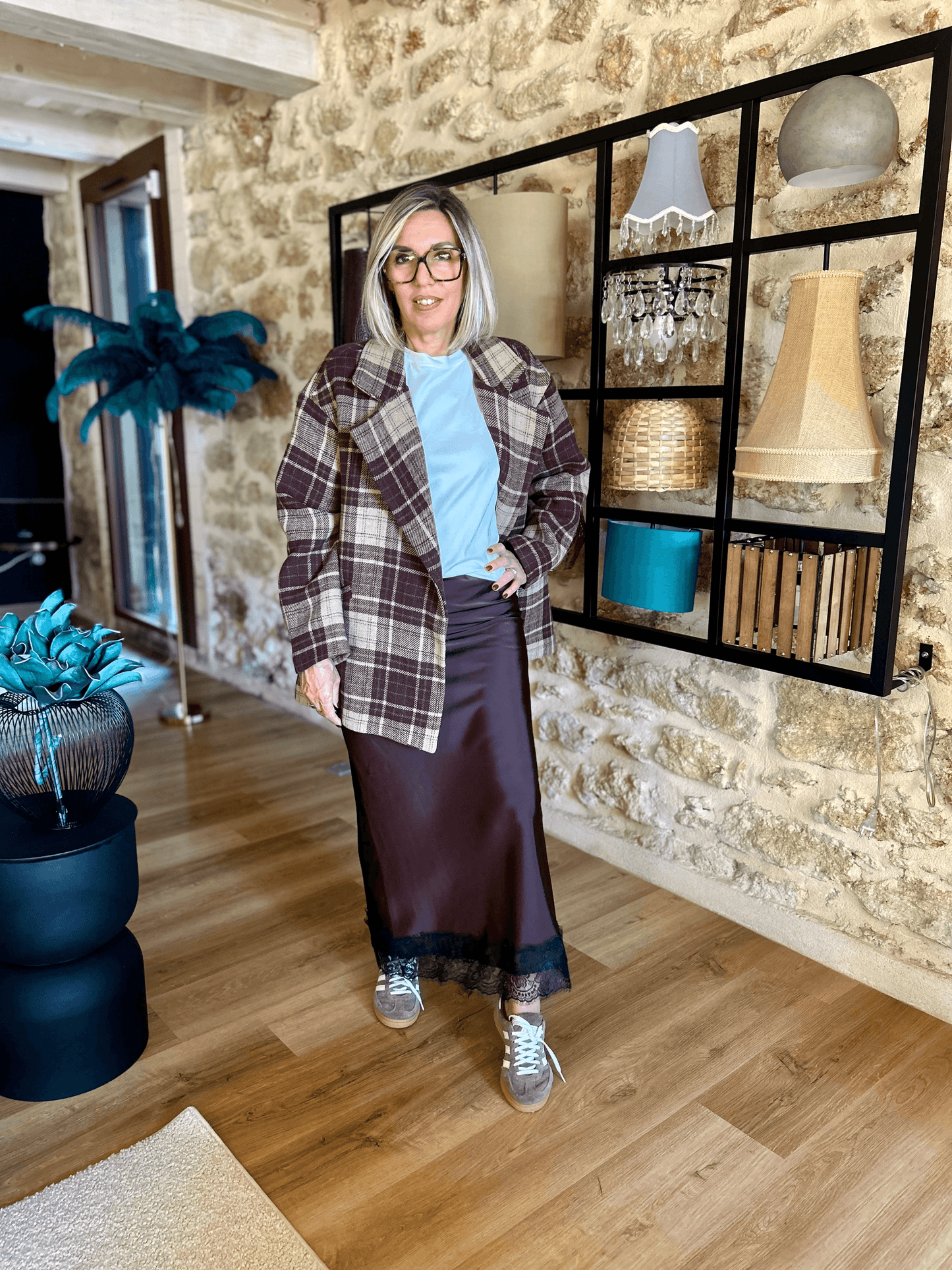 Jupe satinée Liora chocolat avec dentelle, combinée à veste à carreaux et t-shirt bleu clair. Look tendance et confortable Johanna Paris.