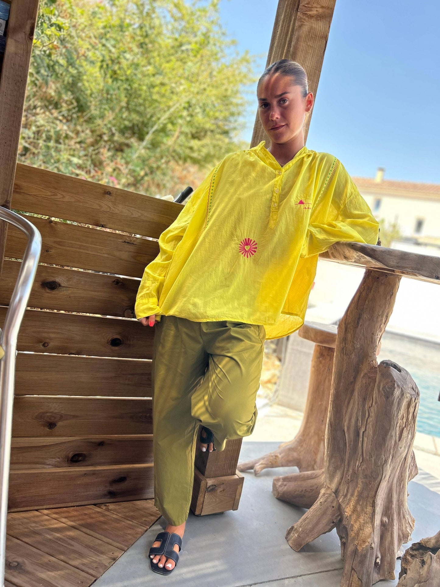 Pantalon Magique Louisa vert olive Johanna Paris, coupe fluide et taille élastique, porté avec une chemise jaune pour un look casual chic.
