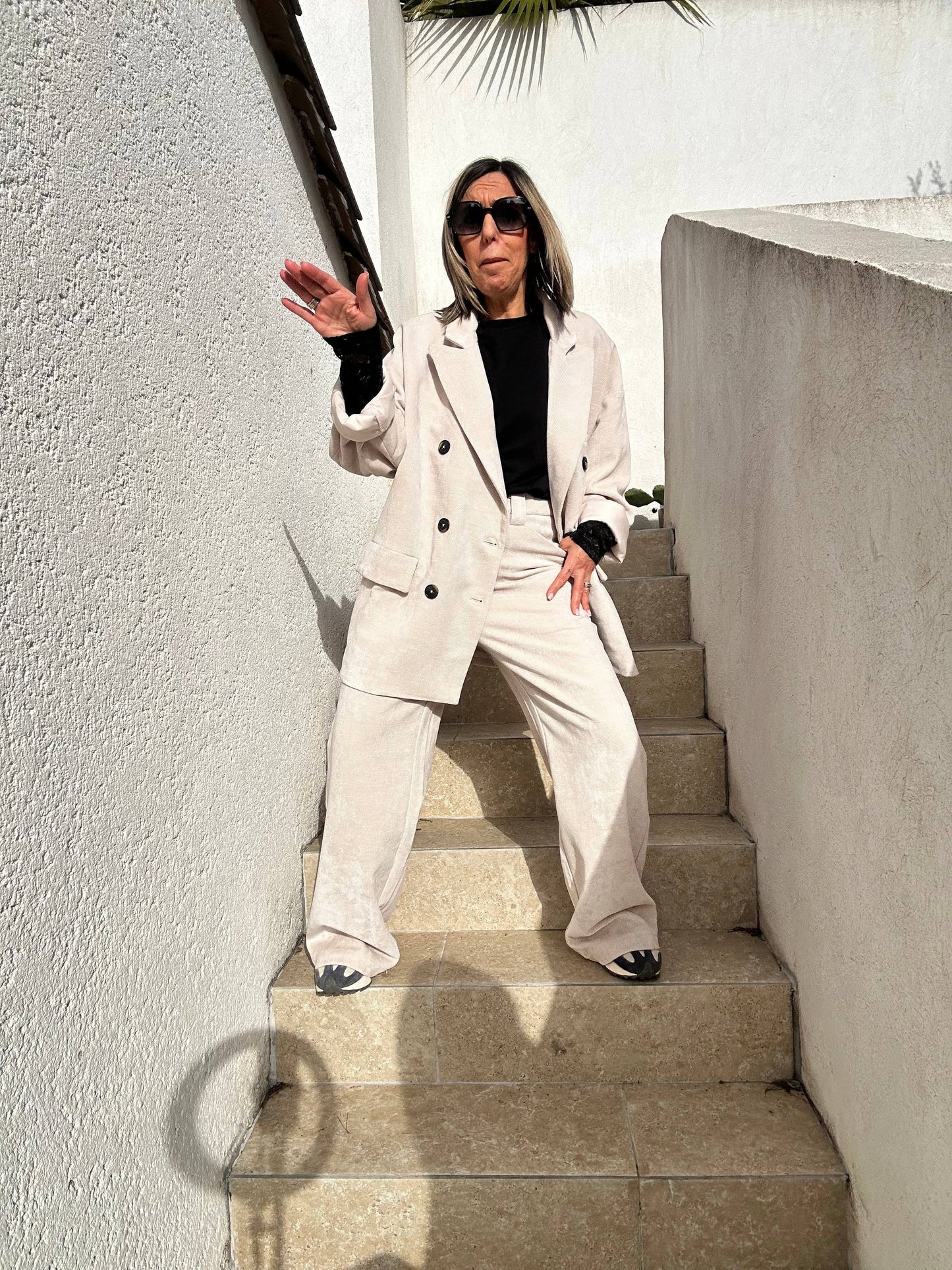 Ensemble chic avec le pantalon Aurélie en velours souple beige, coupe large et taille haute, assorti à une veste beige et un top noir.