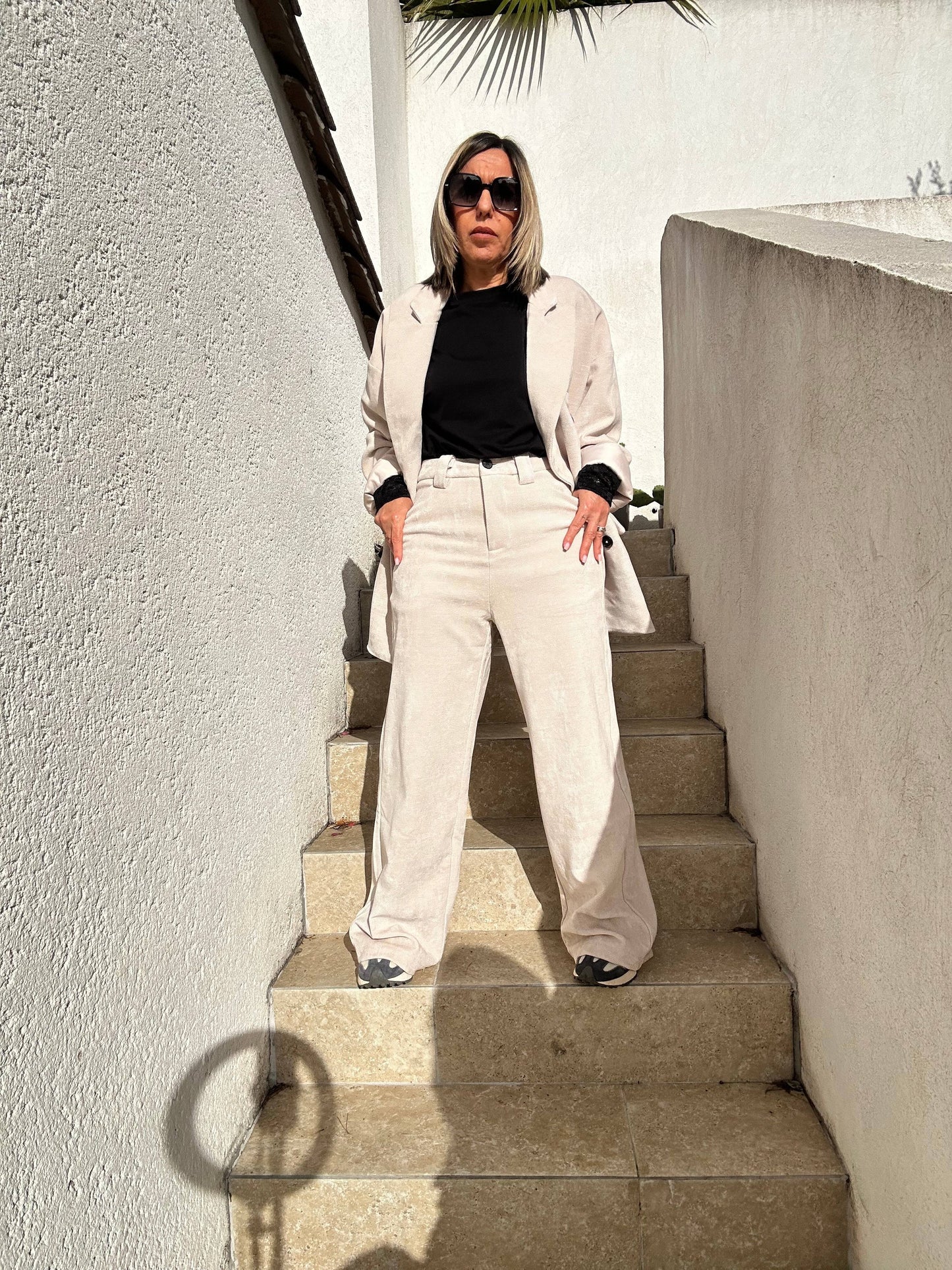 Look élégant avec le pantalon Aurélie en velours souple beige, coupe large et taille haute, porté avec une veste assortie et un top noir.