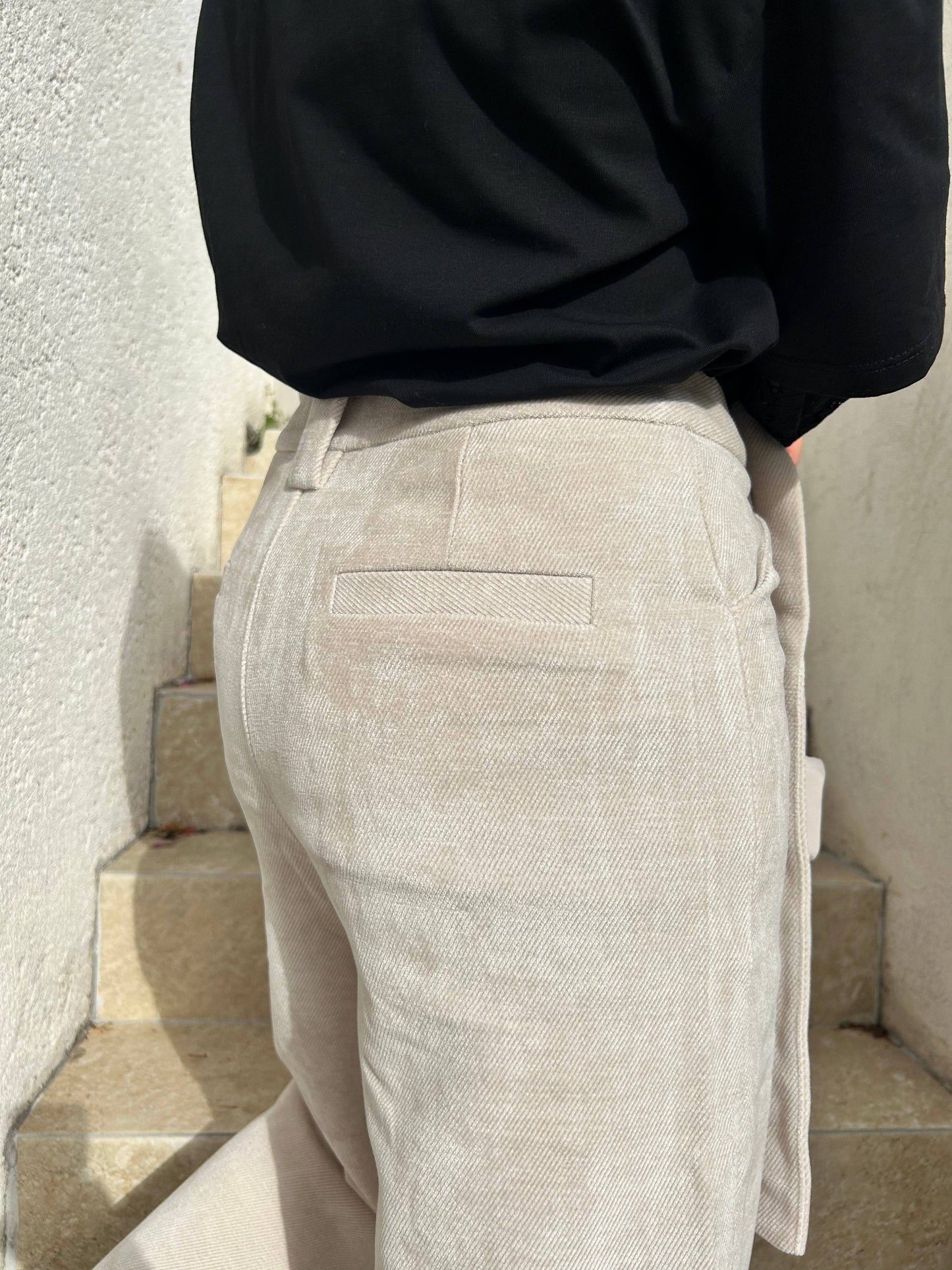 Gros plan sur le pantalon Aurélie en velours souple beige, mettant en valeur sa coupe taille haute et ses finitions élégantes.