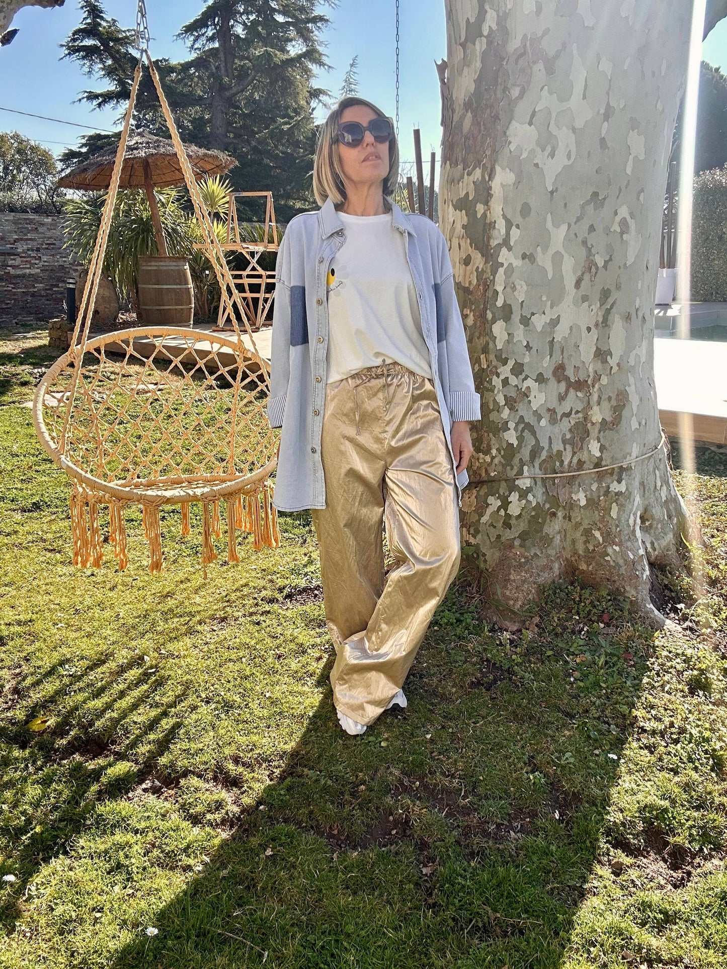 Pantalon oversize doré pour femme, alliant confort et modernité. Son effet brillant et sa coupe fluide en font une pièce phare de la saison.