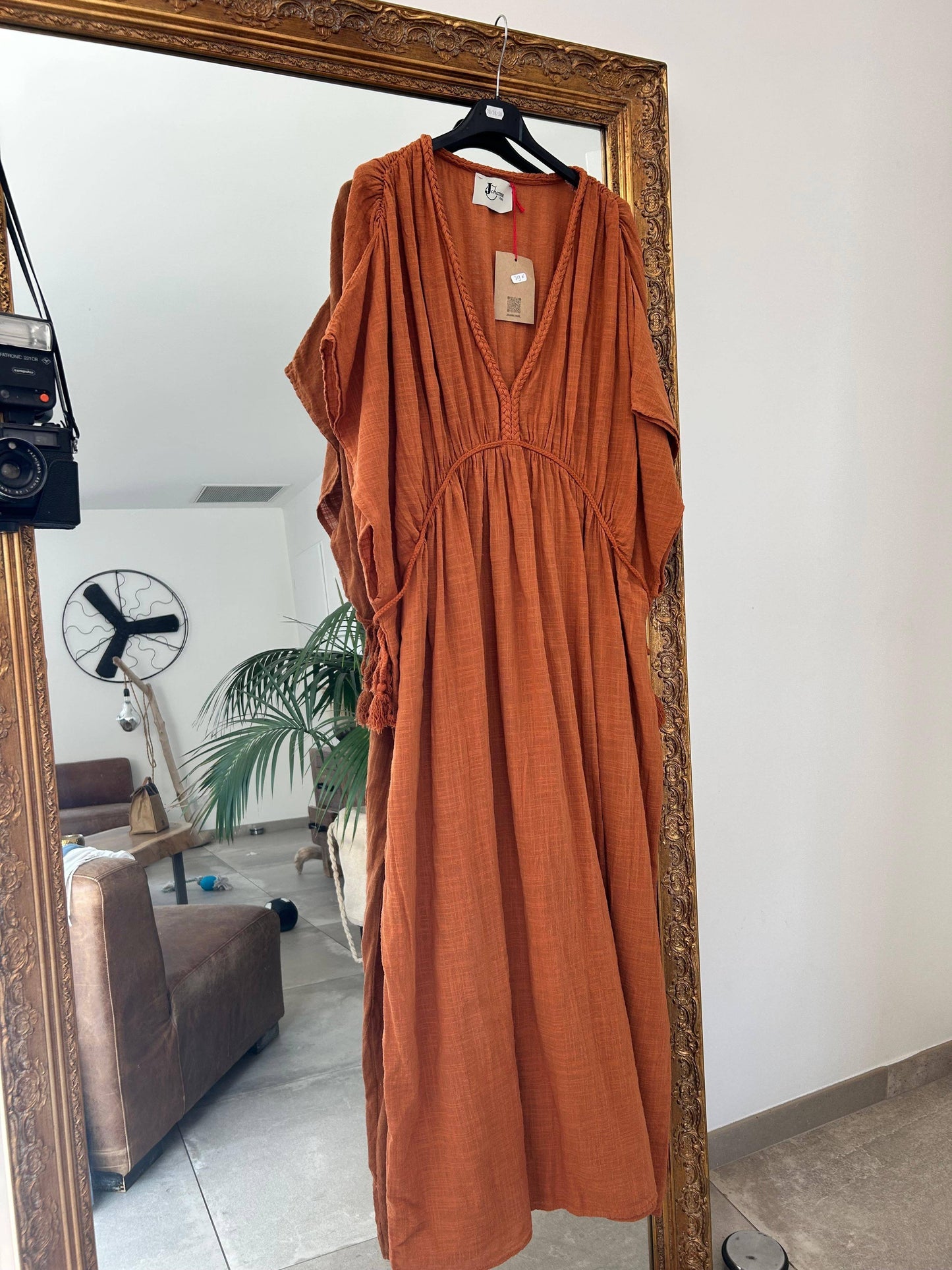 Robe Amaya - Johanna Paris suspendue sur miroir doré, modèle rouille en coton, robe taille unique chic et décontractée pour l'été.