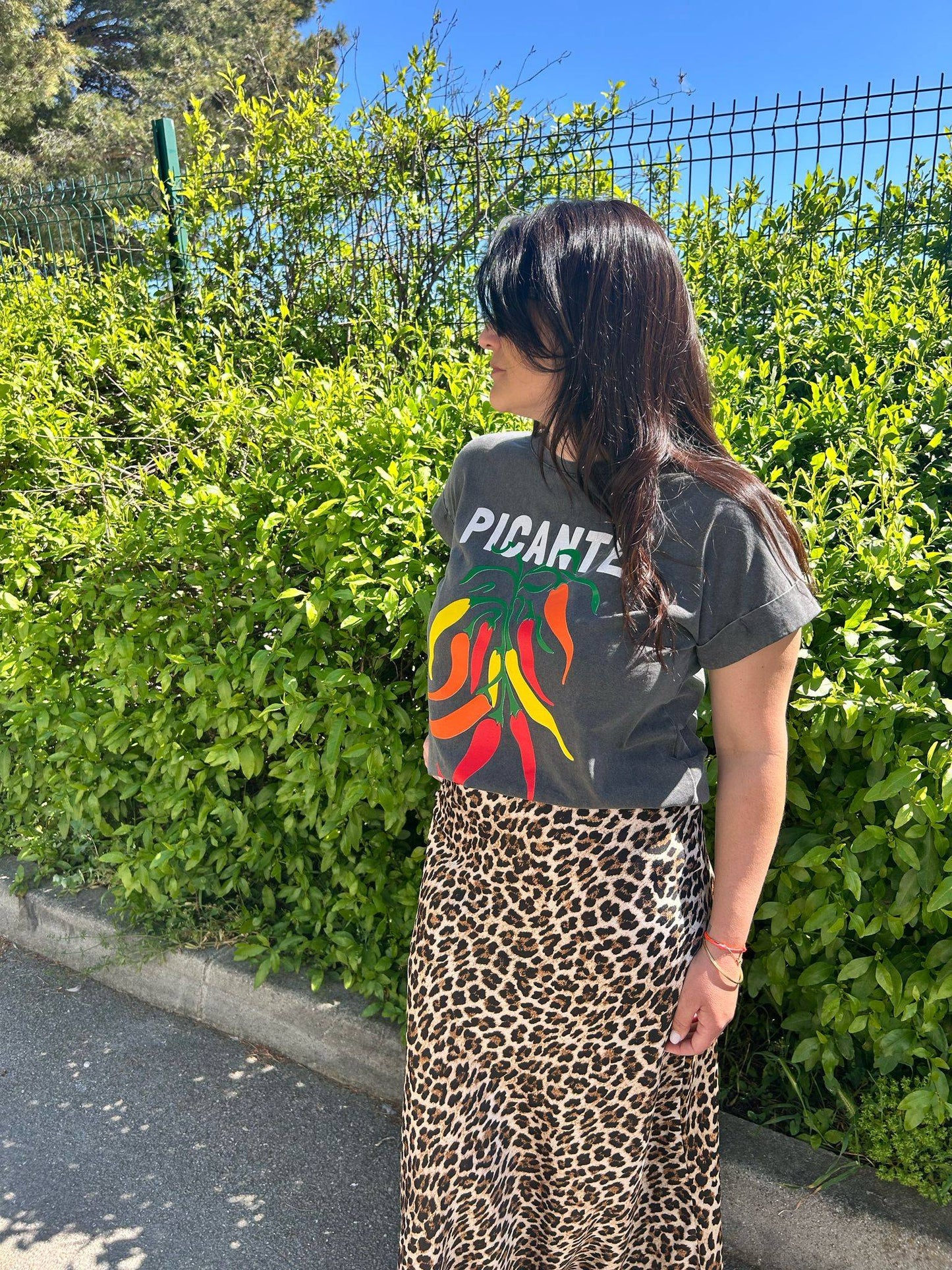 Tee-shirt gris Picante Pepper Print T-Shirt for Trendy Look 2025 avec imprimé piments colorés, associé à une jupe léopard pour l'été 2025.
