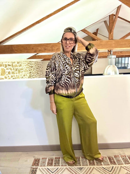 Veste bomber Sacha satinée imprimé zèbre avec nuances olive, chocolat et beige, portée avec un pantalon large vert pour un look chic et tendance automne-hiver 2025.