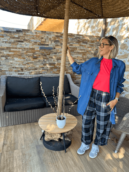Chemise Denim Clara femme en jean fluide portée ouverte sur un t-shirt rouge, look décontracté avec pantalon à carreaux et baskets.