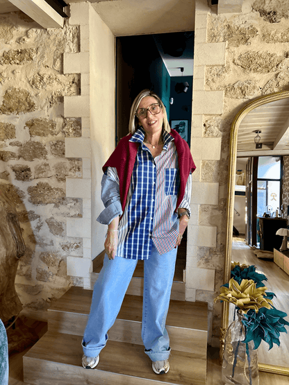 Chemise Alix rayée et à carreaux portée avec pull bordeaux sur les épaules, look urbain automne 2025 pour femme moderne.