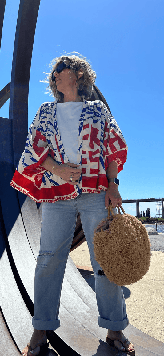 Chemise Été Méditerranée coupe fluide imprimée sardines rouges et bleues, portée avec un jean décontracté. Haut estival tendance pour femme.