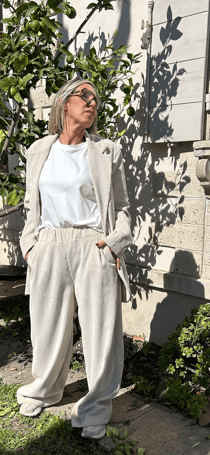 Pantalon Amara large en velours beige, taille élastique, porté avec un blazer coordonné en extérieur, style chic made in Italie.