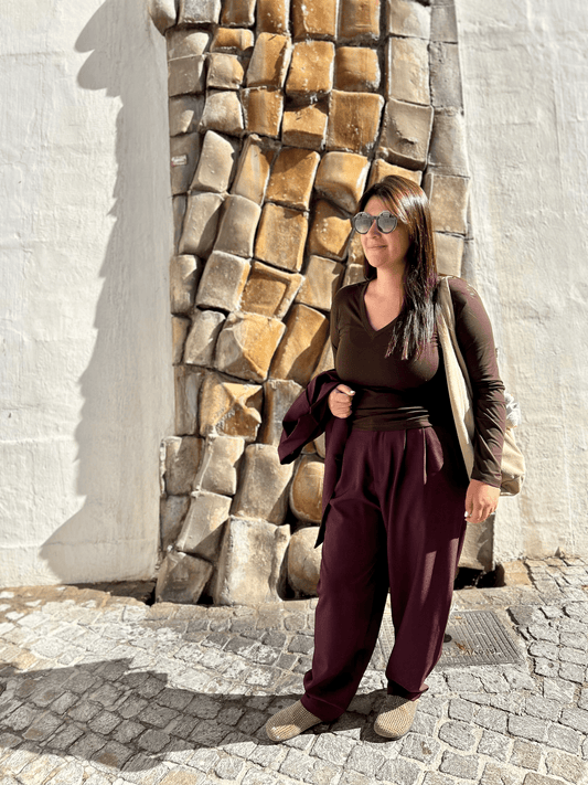 Top chocolat manches longues femme Paula porté avec un pantalon ample bordeaux, look chic et décontracté pour l'automne-hiver 2025.