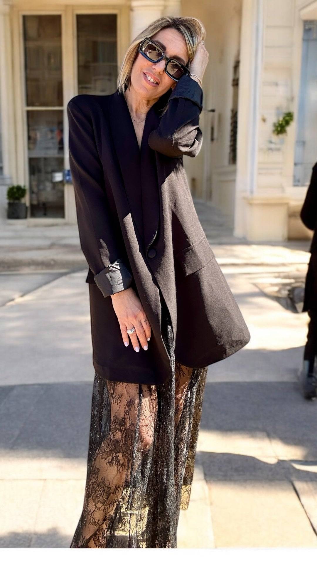 Jupe Diva Boho Chic Lace Maxi Skirt noire associée à un blazer noir élégant, parfaite pour un événement chic en extérieur été 2025.