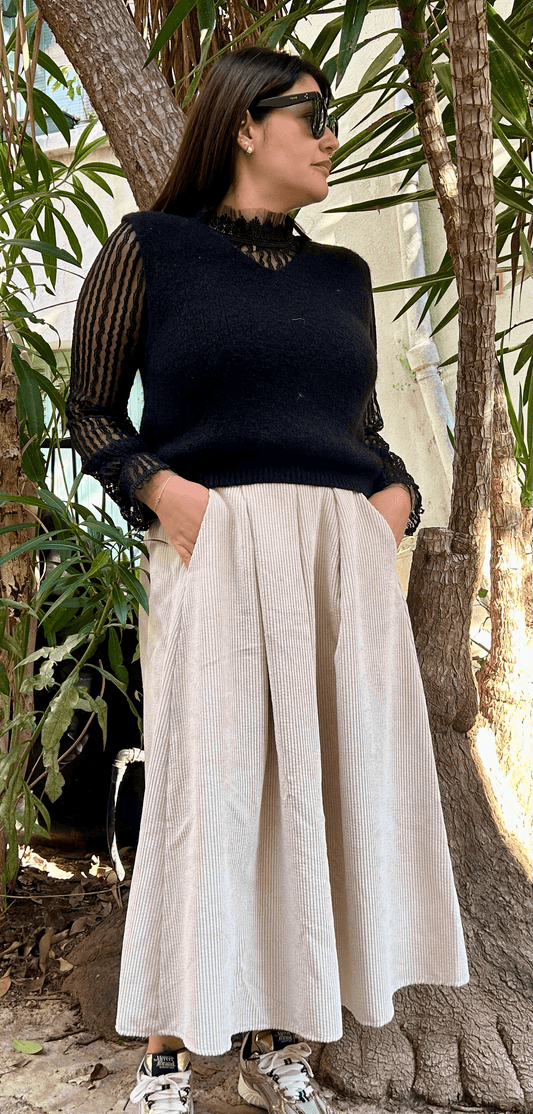 Jupe longue en velours beige Bella portée avec un haut noir élégant, style italien chic pour l'automne hiver 2025. Jupe taille haute fluide et tendance.