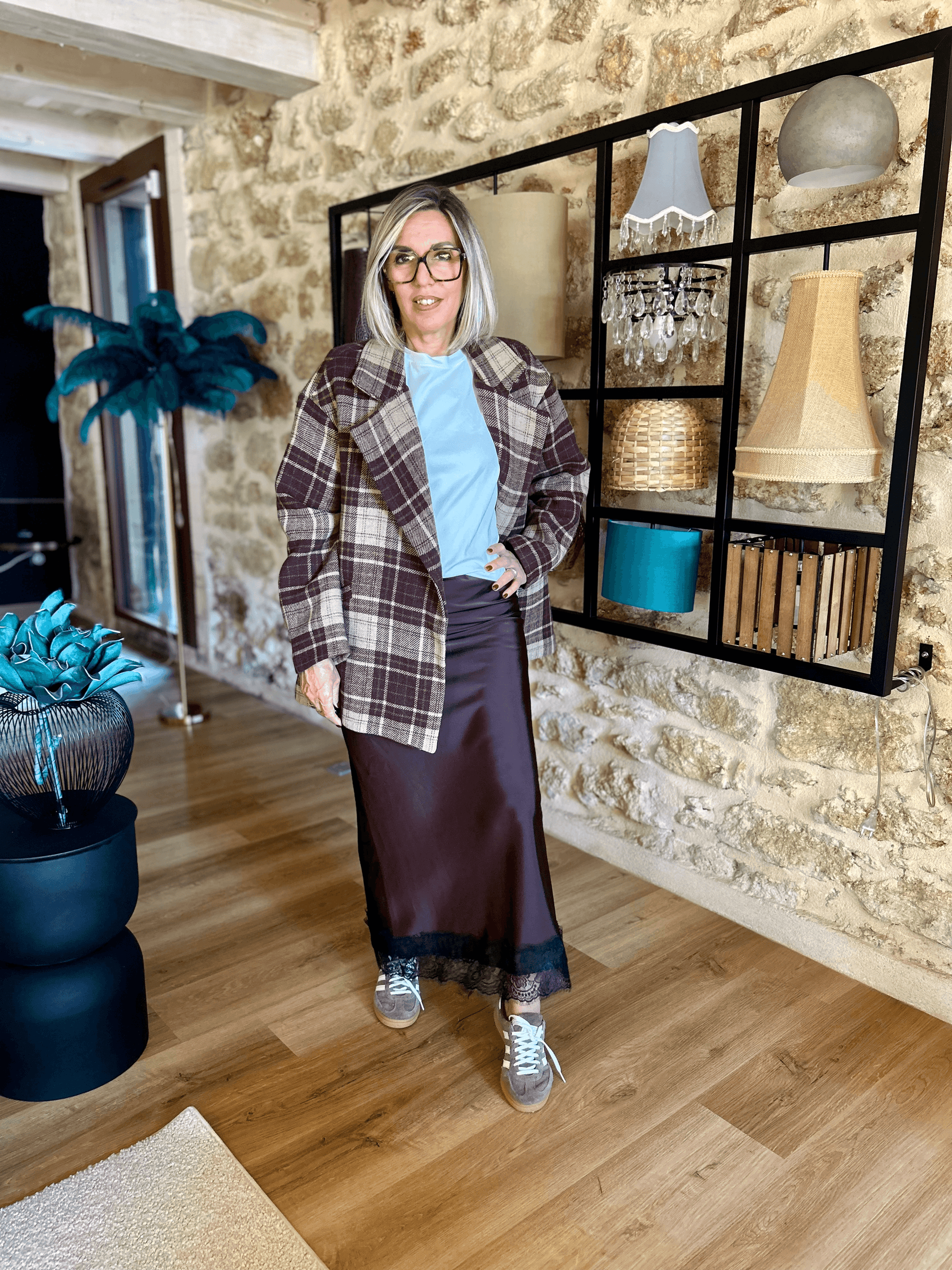 Jupe satinée Liora chocolat avec dentelle, combinée à veste à carreaux et t-shirt bleu clair. Look tendance et confortable Johanna Paris.