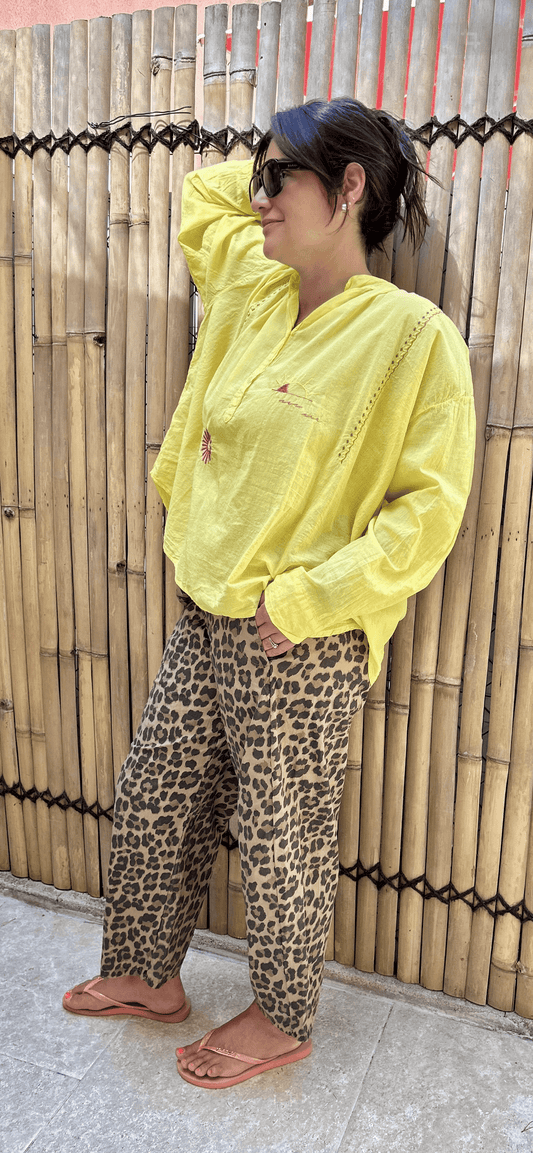 Pantalon LÉO femme imprimé léopard 100% coton, coupe droite, taille élastique, porté avec une chemise jaune. Confortable et fabriqué en Italie.