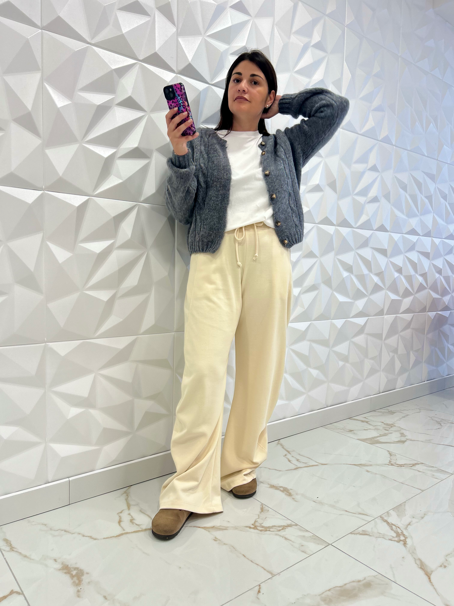 Pantalon Luna - jogging chic femme en écru avec coupe ballon, associé à un cardigan gris pour un style casual élégant et confortable.