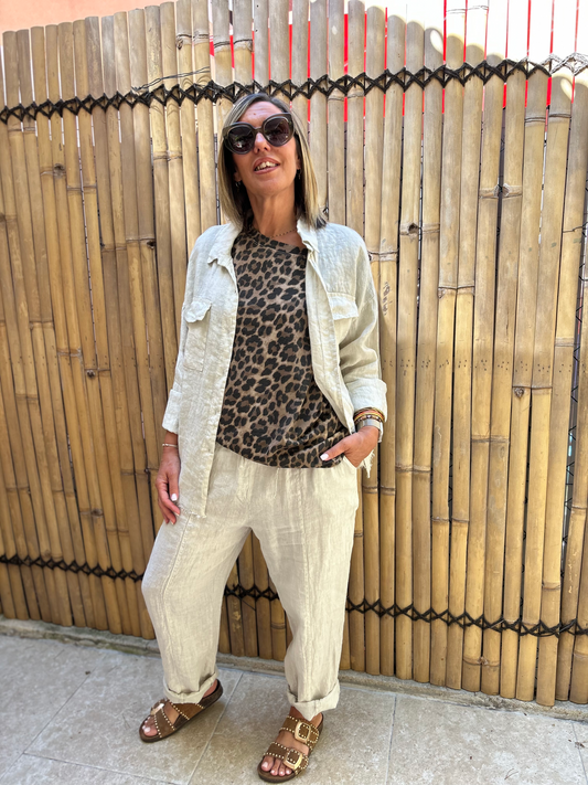 Pantalon LUCA en lin italien beige porté avec une chemise assortie et un t-shirt léopard, style décontracté chic pour l'été.