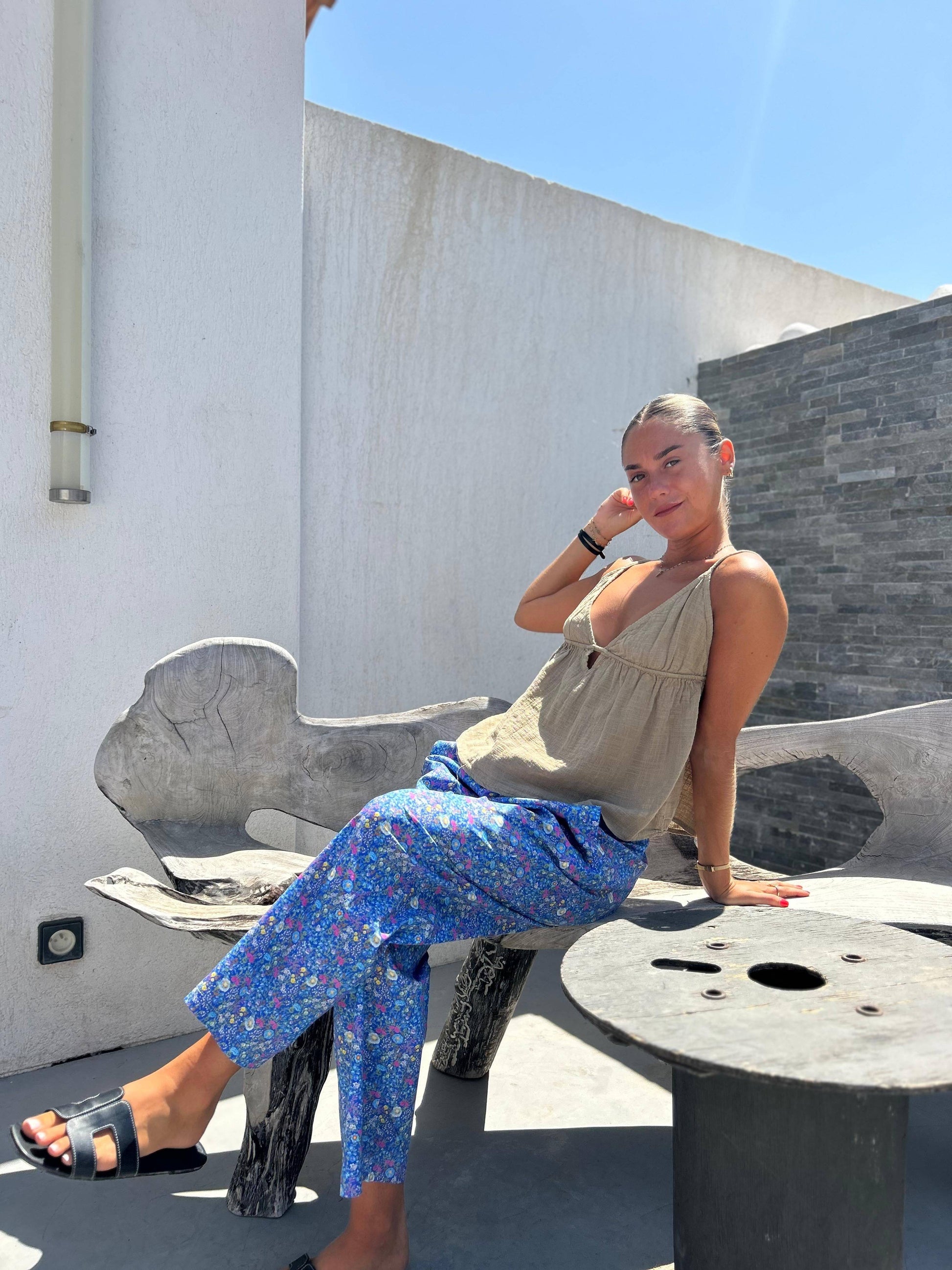 Pantalon Fiora Magic bleu fleuri avec taille élastique, porté en extérieur avec un top léger, alliant confort et style pour l'été.