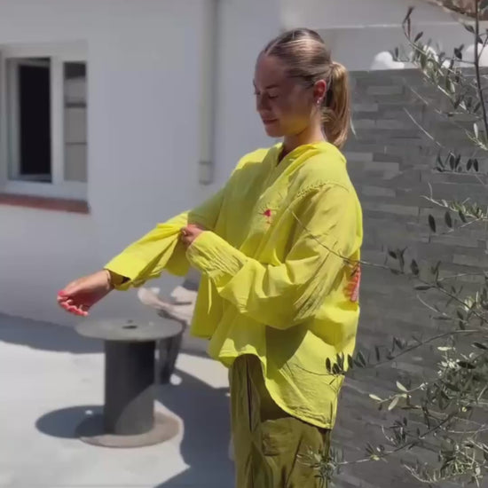 Pantalon Magique Louisa vert olive de Johanna Paris porté avec une chemise jaune, coupe ample et taille élastique pour un confort optimal.