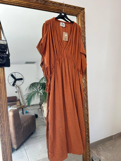 Robe Amaya - Johanna Paris suspendue sur miroir doré, modèle rouille en coton, robe taille unique chic et décontractée pour l'été.