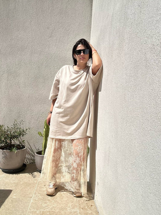 Robe T-Shirt Oversize beige imprimé cœur, style décontracté en coton élasthanne, portée avec jupe en dentelle, prêt-à-porter féminin été 2025.