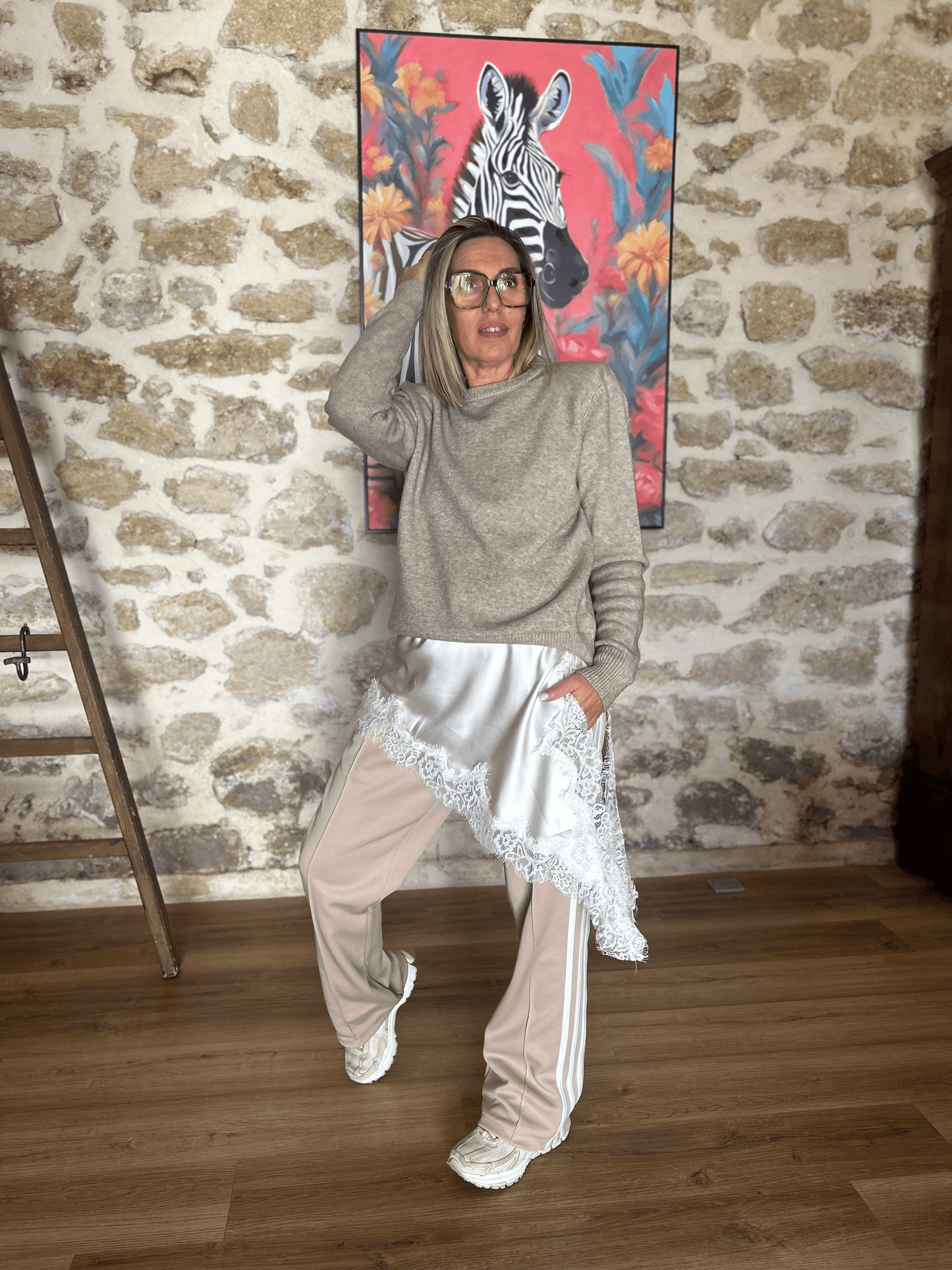 Robe asymétrique satinée écrue Luna chic & tendance superposée sur un pantalon de sport beige, look mode automne-hiver original et urbain.