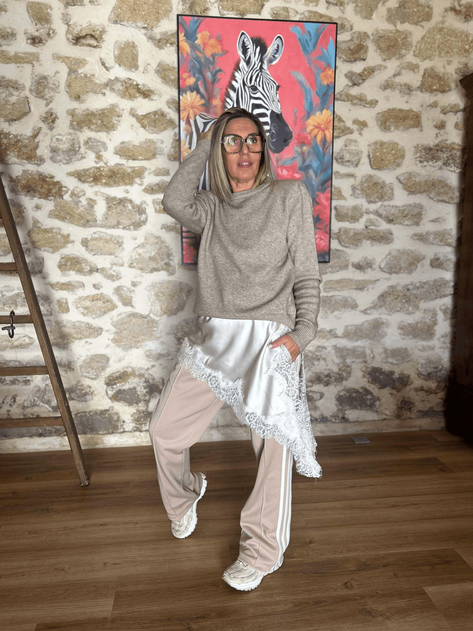 Robe asymétrique satinée écrue Luna chic & tendance superposée sur un pantalon de sport beige, look mode automne-hiver original et urbain.