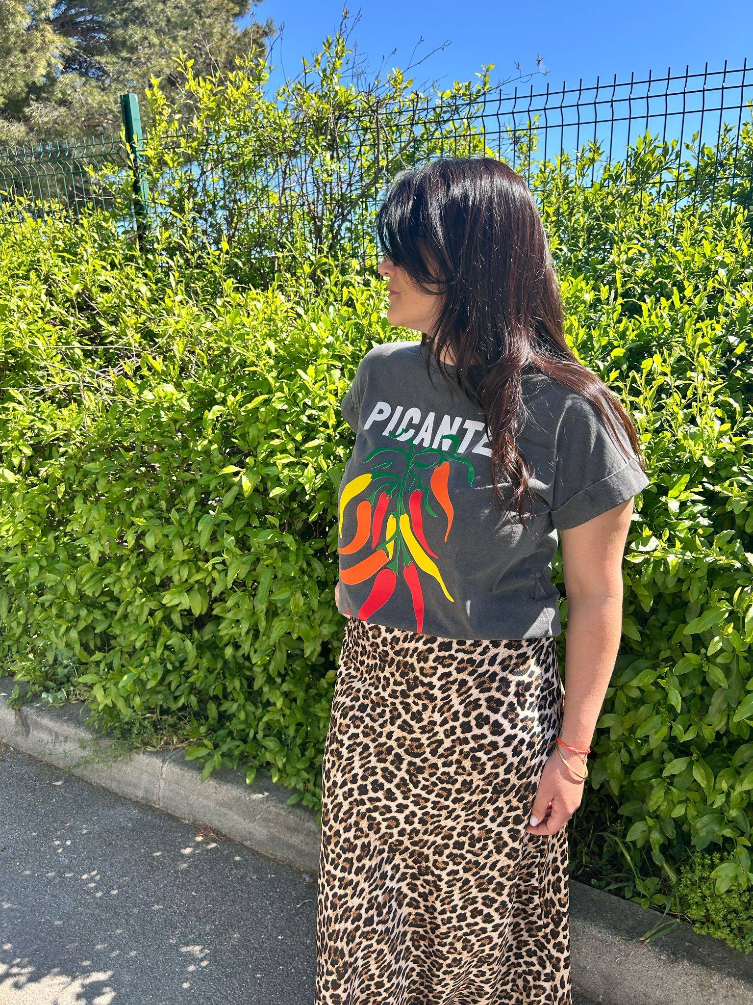 Tee-shirt gris Picante Pepper Print T-Shirt for Trendy Look 2025 avec imprimé piments colorés, associé à une jupe léopard pour l'été 2025.